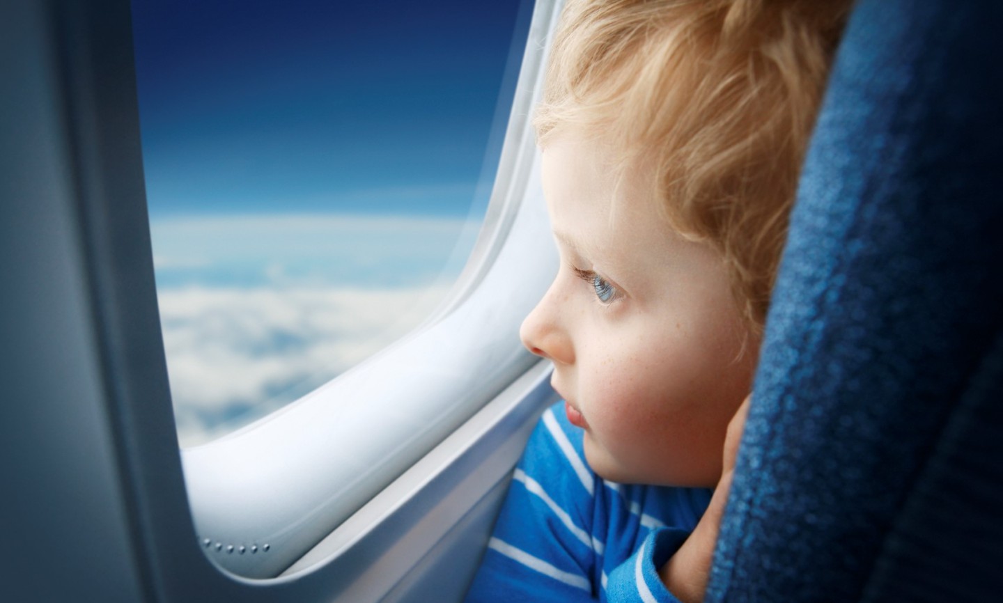 Boy watching sky through the airplane window